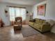 Living room features a green couch, armchair, and decorative accents at 8128 Fairways Cir # R101, Ocala, FL 34472