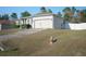 House exterior with a green roof, attached garage, and a long driveway at 8457 Sw 138Th Pl, Ocala, FL 34473