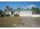 One-story house with a green roof, attached garage, and landscaping at 8457 Sw 138Th Pl, Ocala, FL 34473