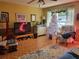 Bright living room featuring hardwood floors, a cozy armchair, and a large TV at 8473 Sw 106Th St, Ocala, FL 34481