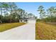 Newly built home with gray exterior, white garage door, and a long driveway at 89 Malauka Pass Crse, Ocklawaha, FL 32179