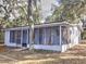 Ranch-style home with screened porch and mature trees at 10655 Ne 224Th Place Rd, Fort Mc Coy, FL 32134