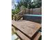 Spacious wooden deck with a built-in hot tub and privacy screen at 113 Guava Ter, Ocklawaha, FL 32179