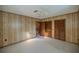Spacious bedroom with wood paneling, carpet, and a door at 11360 Se 188Th Ave, Ocklawaha, FL 32179
