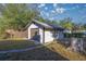 Detached garage with brown door, located in a yard with trees at 11360 Se 188Th Ave, Ocklawaha, FL 32179