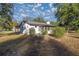 White house exterior with screened porch, surrounded by trees and yard at 11360 Se 188Th Ave, Ocklawaha, FL 32179