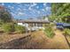 White house exterior with screened porch, surrounded by trees and yard at 11360 Se 188Th Ave, Ocklawaha, FL 32179