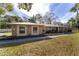 Charming stone house with a metal roof, mature trees, and a wide driveway at 2528 Se 15Th St, Ocala, FL 34471