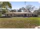 Stone house with a metal roof, large windows, and a lush lawn at 2528 Se 15Th St, Ocala, FL 34471