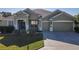 Single-story house with green exterior, two-car garage, and landscaped lawn at 8852 Se 119Th St, Summerfield, FL 34491