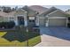 Single-story house with green exterior, two-car garage, and landscaped lawn at 8852 Se 119Th St, Summerfield, FL 34491