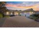 Evening view of a charming two-story house with a brick driveway and two-car garage at 9015 Sw 86Th Loop, Ocala, FL 34481