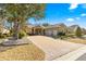 House exterior with a three-car garage and brick driveway at 9015 Sw 86Th Loop, Ocala, FL 34481