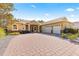 House exterior with a three-car garage and brick driveway at 9015 Sw 86Th Loop, Ocala, FL 34481