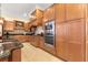 Modern kitchen featuring wood cabinets, granite counters, and stainless steel appliances at 9015 Sw 86Th Loop, Ocala, FL 34481