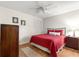 Bedroom with red bedding, wood floors, and ceiling fan at 9158 Sw 91St Ter, Ocala, FL 34481
