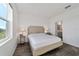 Bright bedroom with wood-look floors, large window, and ensuite bathroom access at 10406 Sw 96 Loop, Ocala, FL 34481