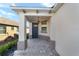 Covered entryway with gray door and brick flooring at 10406 Sw 96 Loop, Ocala, FL 34481