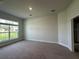 Large living room with carpeted floor and large window at 3 Willow Trl, Ocala, FL 34472