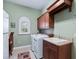 Bright laundry room with washer, dryer, cabinets, and built-in desk at 3000 Nw 79Th Avenue Rd, Ocala, FL 34482