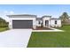 White house with gray garage door, landscaping, and walkway at 541 Marion Oaks Golf Rd, Ocala, FL 34473