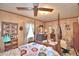 Charming bedroom with a four-poster bed, window, and ceiling fan at 6121 County Road 547 N, Davenport, FL 33837
