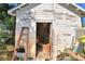 White wooden workshop with open door, showing tools and equipment inside at 6121 County Road 547 N, Davenport, FL 33837