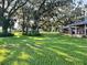Large grassy yard with oak trees and outbuildings at 4880 Bannon Island Rd, Haines City, FL 33844