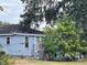Side view of a light blue house with mature trees at 323 Dorsett Ave, Lake Wales, FL 33853