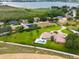 Aerial view of a luxurious house with a pool, surrounded by lush greenery and a lake at 3082 Landings Ct, Haines City, FL 33844