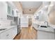 Modern white kitchen featuring stainless steel appliances and hardwood floors at 110 Woden Way, Winter Haven, FL 33884