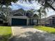 Two-story house with a green garage door and manicured lawn at 2213 Mallory Cir, Haines City, FL 33844
