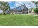 Landscaped backyard with a large screened enclosure at 514 Hillside Dr, Auburndale, FL 33823