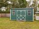 Green metal storage shed with double doors and windows at 5490 Morgan Rd, Lakeland, FL 33810