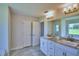 Elegant bathroom with double vanity, granite countertop, and large mirror at 4024 Tullamore Ln, Auburndale, FL 33823