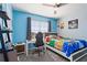 Blue bedroom with a bed, desk, chair, and window at 856 Sun Burst Rd, Winter Haven, FL 33880