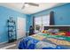 Blue bedroom with a bed, dresser, and window with blinds at 856 Sun Burst Rd, Winter Haven, FL 33880
