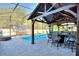 Covered patio area by the pool with a table, chairs, and a trampoline at 856 Sun Burst Rd, Winter Haven, FL 33880