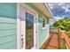 Side view of teal house showcasing stained glass door and deck overlooking water at 4920 Old Lucerne Park Ne Rd, Winter Haven, FL 33881