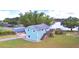 Cute light blue house with a deck and detached garage, waterfront property with lush green grass at 4920 Old Lucerne Park Ne Rd, Winter Haven, FL 33881