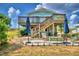 Two-story house with a large deck, patio furniture, and umbrellas in the backyard at 4920 Old Lucerne Park Ne Rd, Winter Haven, FL 33881