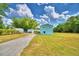 Large backyard with a gravel driveway and green grass at 4920 Old Lucerne Park Ne Rd, Winter Haven, FL 33881