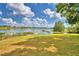 Picturesque view of a calm lake with a dock and lush green grass at 4920 Old Lucerne Park Ne Rd, Winter Haven, FL 33881