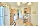 Bright kitchen with white appliances and light wood cabinets at 1608 Forest Hills Ln, Haines City, FL 33844
