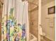 Bathroom with shower/tub combo, floral shower curtain, and neutral tile at 1608 Forest Hills Ln, Haines City, FL 33844