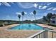 Inviting community pool with lounge chairs and palm trees at 1608 Forest Hills Ln, Haines City, FL 33844