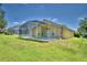 Backyard oasis with a screened pool and a spacious grassy area at 1608 Forest Hills Ln, Haines City, FL 33844