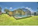 Backyard view of home with pool and lawn at 1608 Forest Hills Ln, Haines City, FL 33844