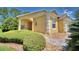 House exterior showcasing a walkway, landscaping, and a yellow painted exterior at 1608 Forest Hills Ln, Haines City, FL 33844
