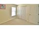 Bright bedroom with window, double doors leading to closet, and neutral colored carpet at 1608 Forest Hills Ln, Haines City, FL 33844